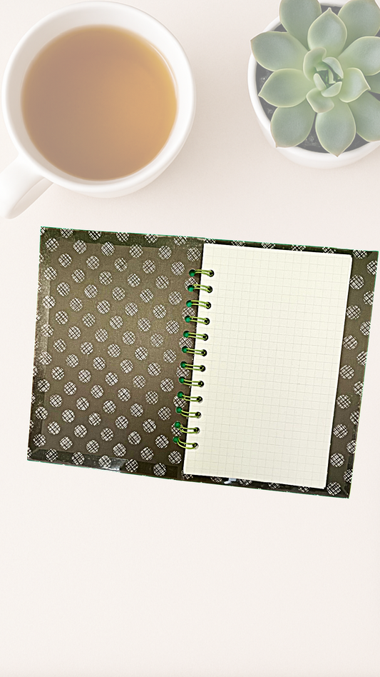 Open notebook with a white page, cup of tea, and succulent plant on a white surface