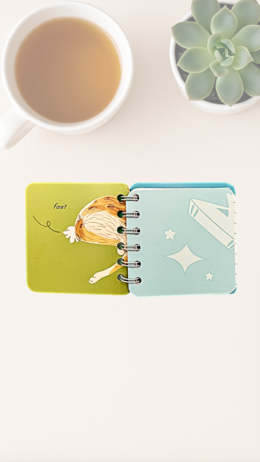 Small notebook with colorful illustration on inside cover of a rabbit butt that says "fast"