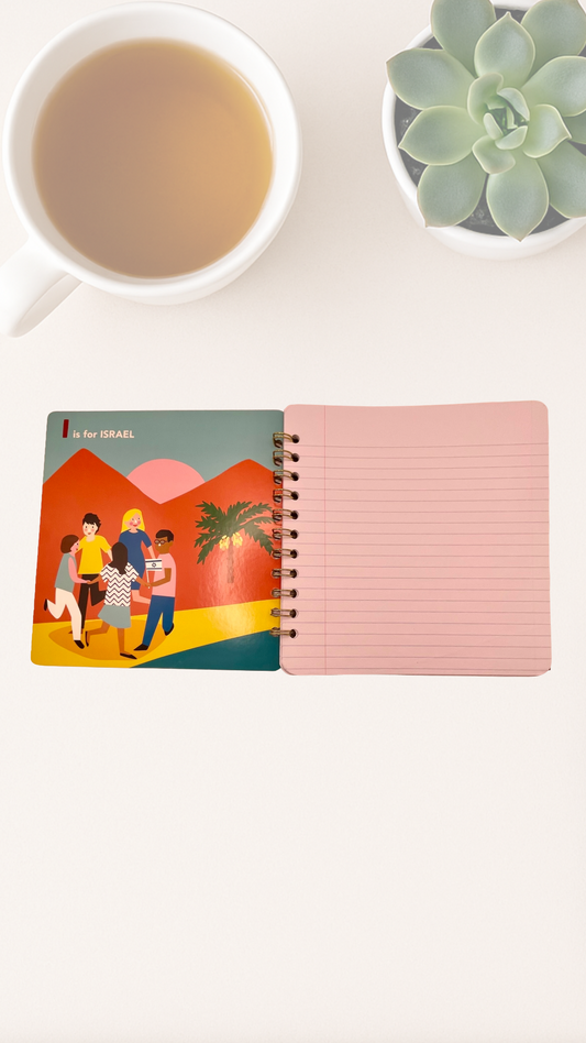 Notebook with colorful cover featuring people and palm trees that says I is for Israel