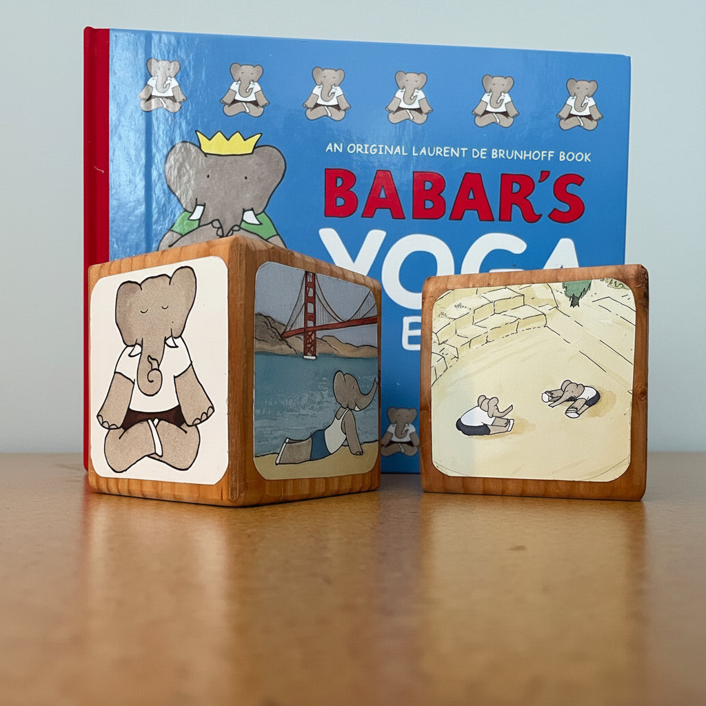 Wooden blocks with illustrations of an elephant and a bear, in front of a book titled 'Babar's Yoga'.