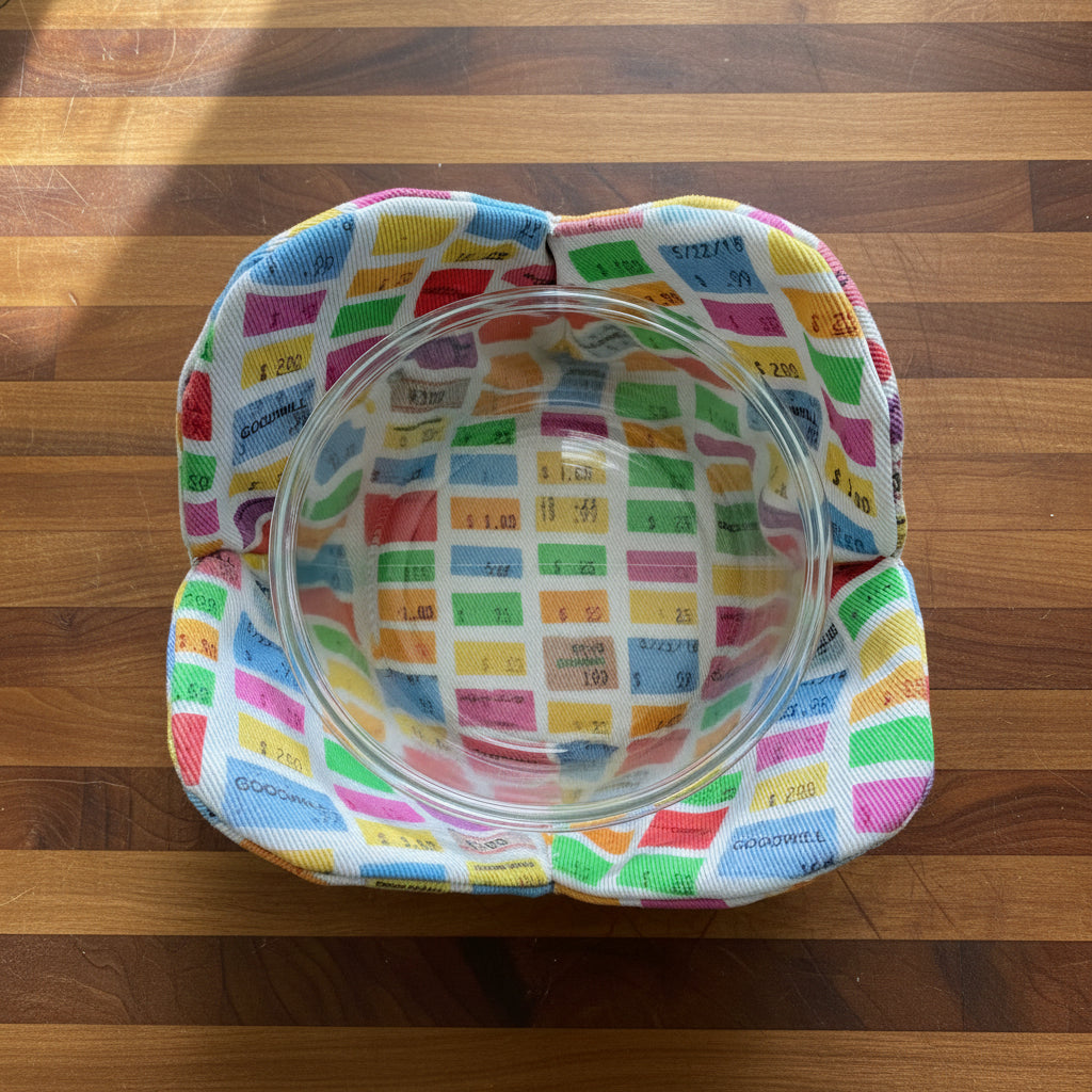 Colorful patterned bowl cover with Goodwill price tags with a clear bowl inside 