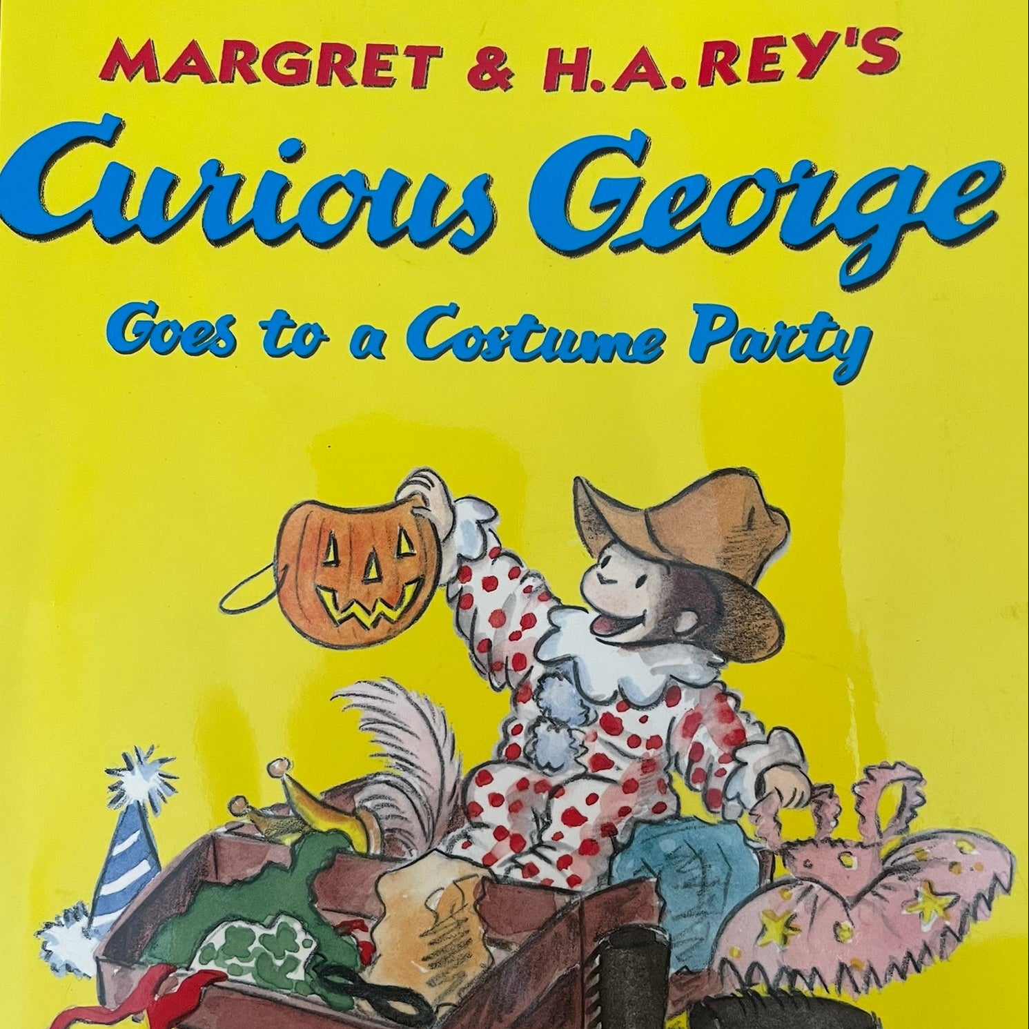 Book cover of 'Curious George Goes to a Costume Party' with a cartoon character and Halloween-themed items.