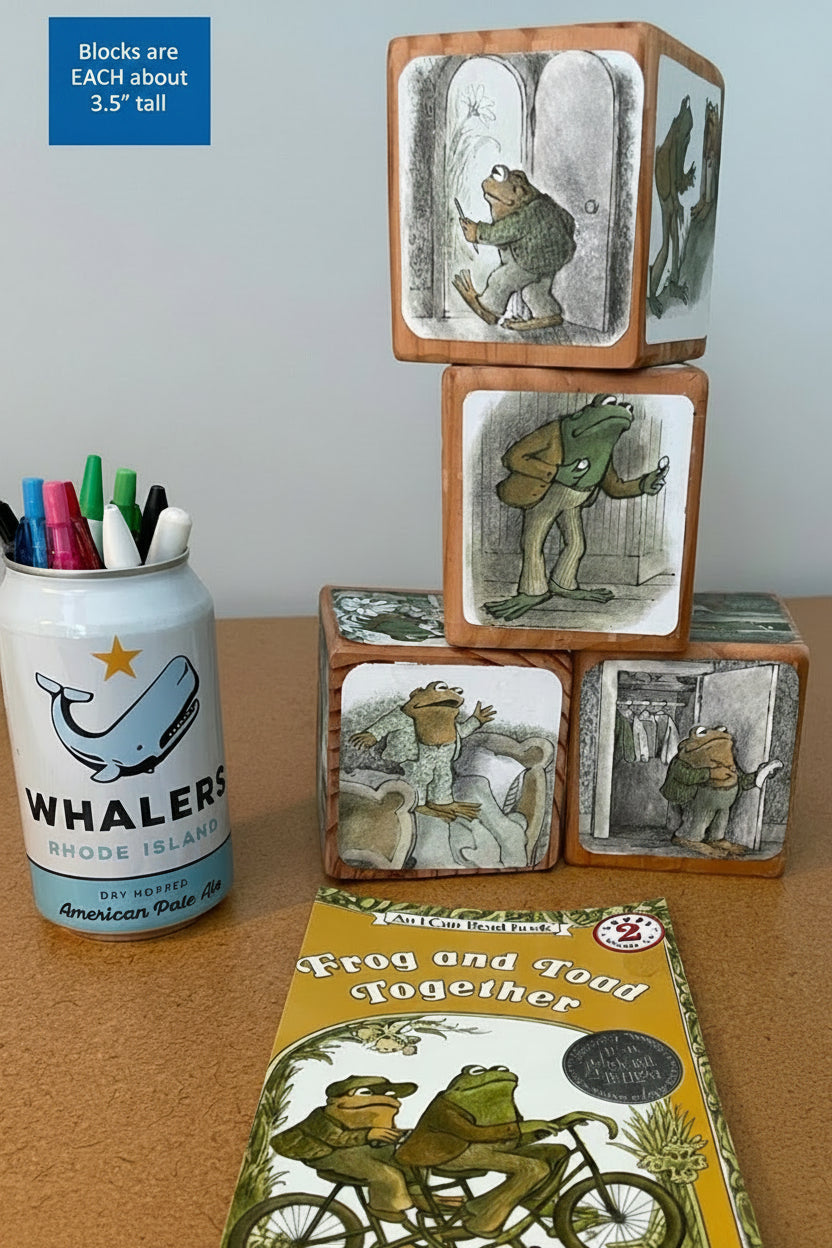 Stack of wooden blocks with illustrations and a book titled 'Frog and Toad Together' by Arnold Lobel on a table.