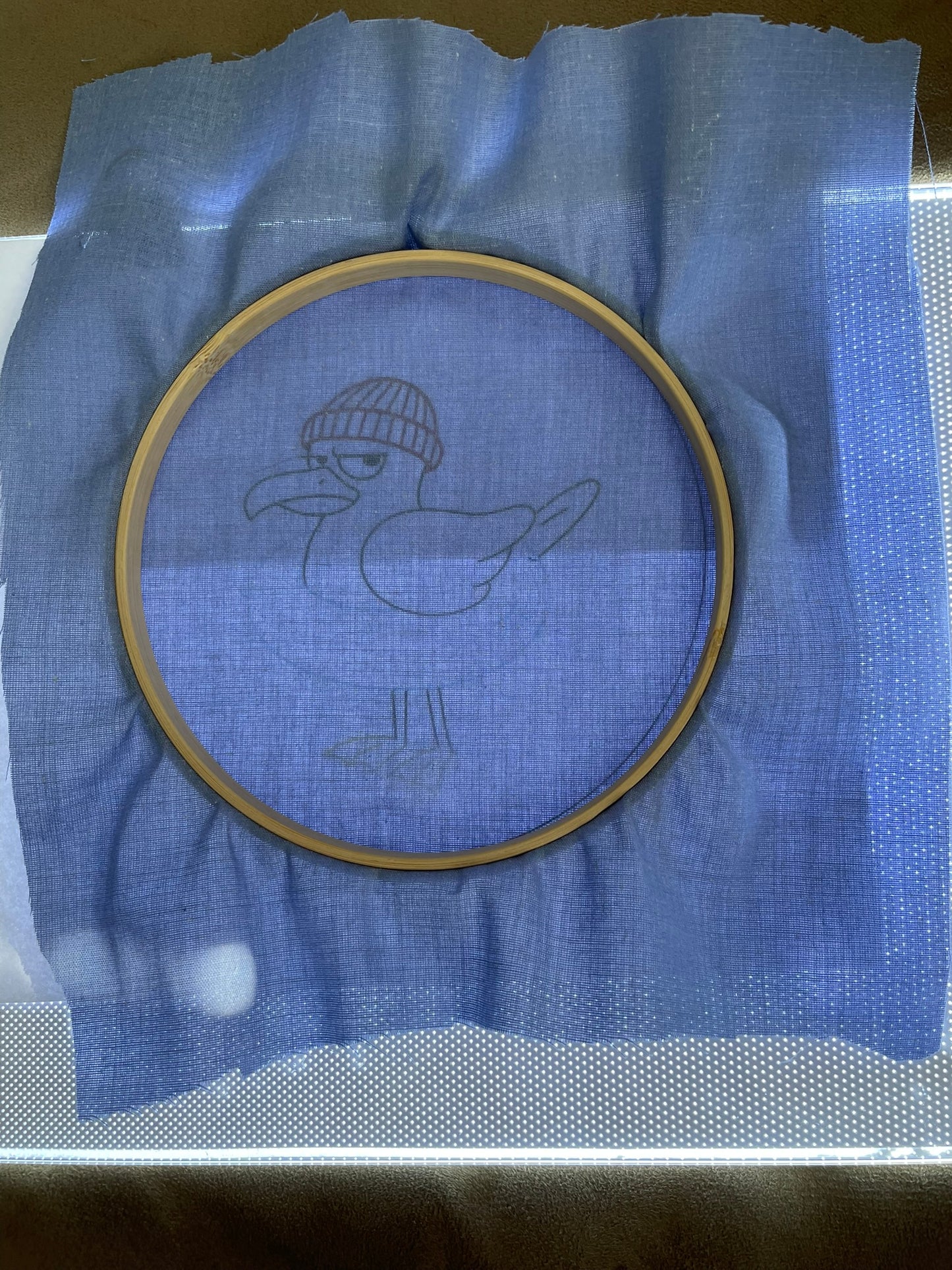 Embroidery hoop with a bird design on blue fabric