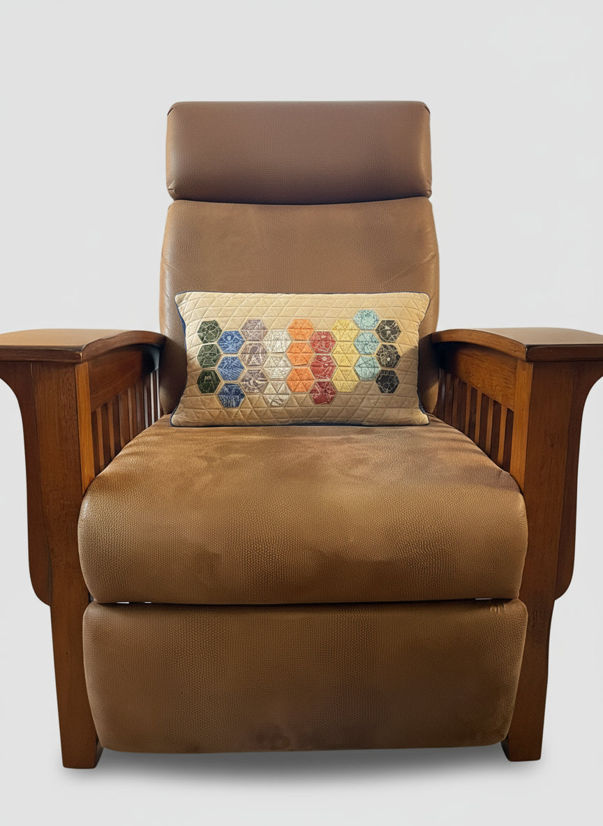 Brown armchair with a colorful Charley Harper Endpapers fabric hexagonal patterned pillow in a living room setting.