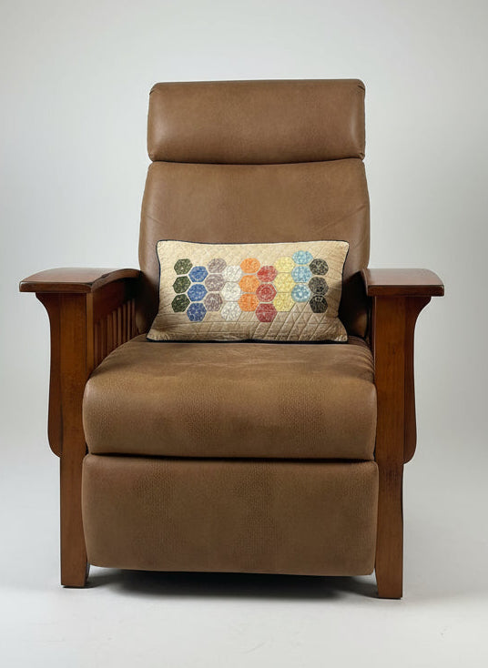 Brown armchair with a colorful pillow on a gray background