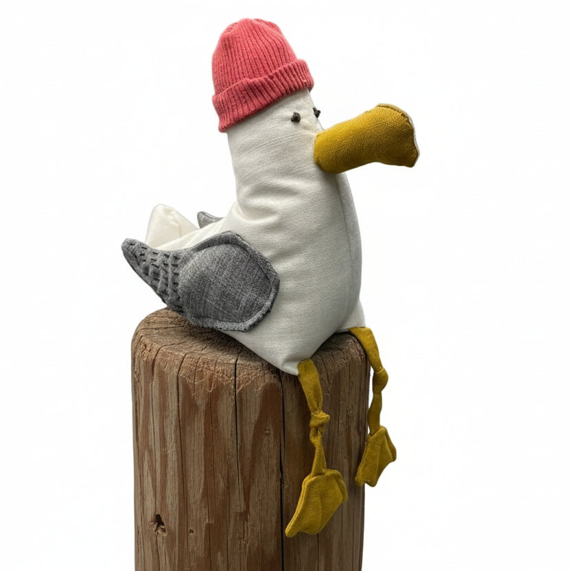 Plush toy bird with a pink hat on top of a green container