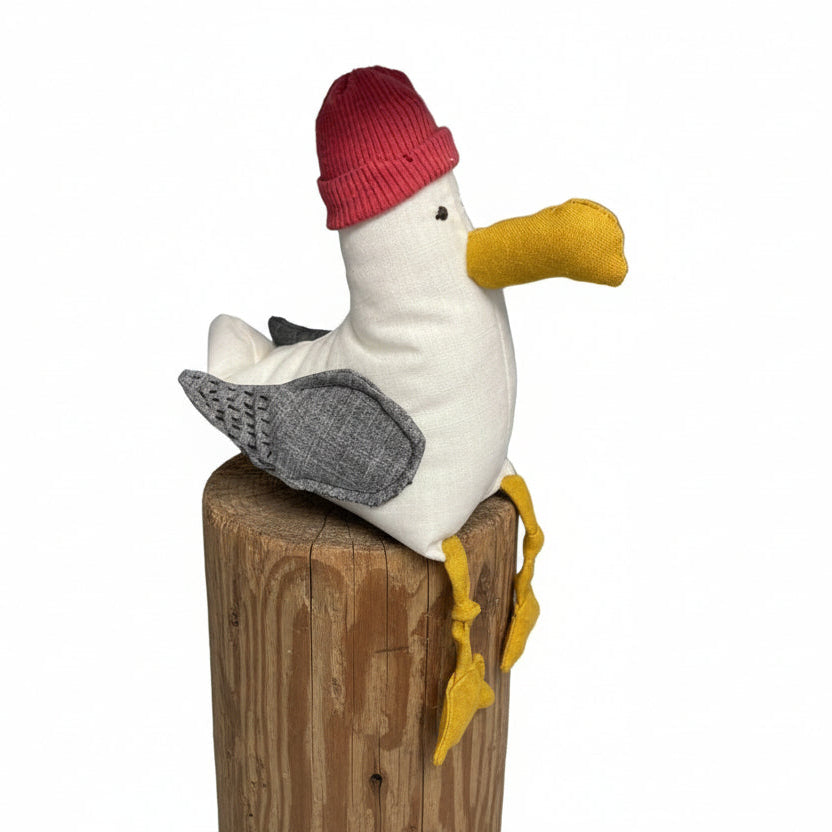 Plush seagull toy with a red hat on top 