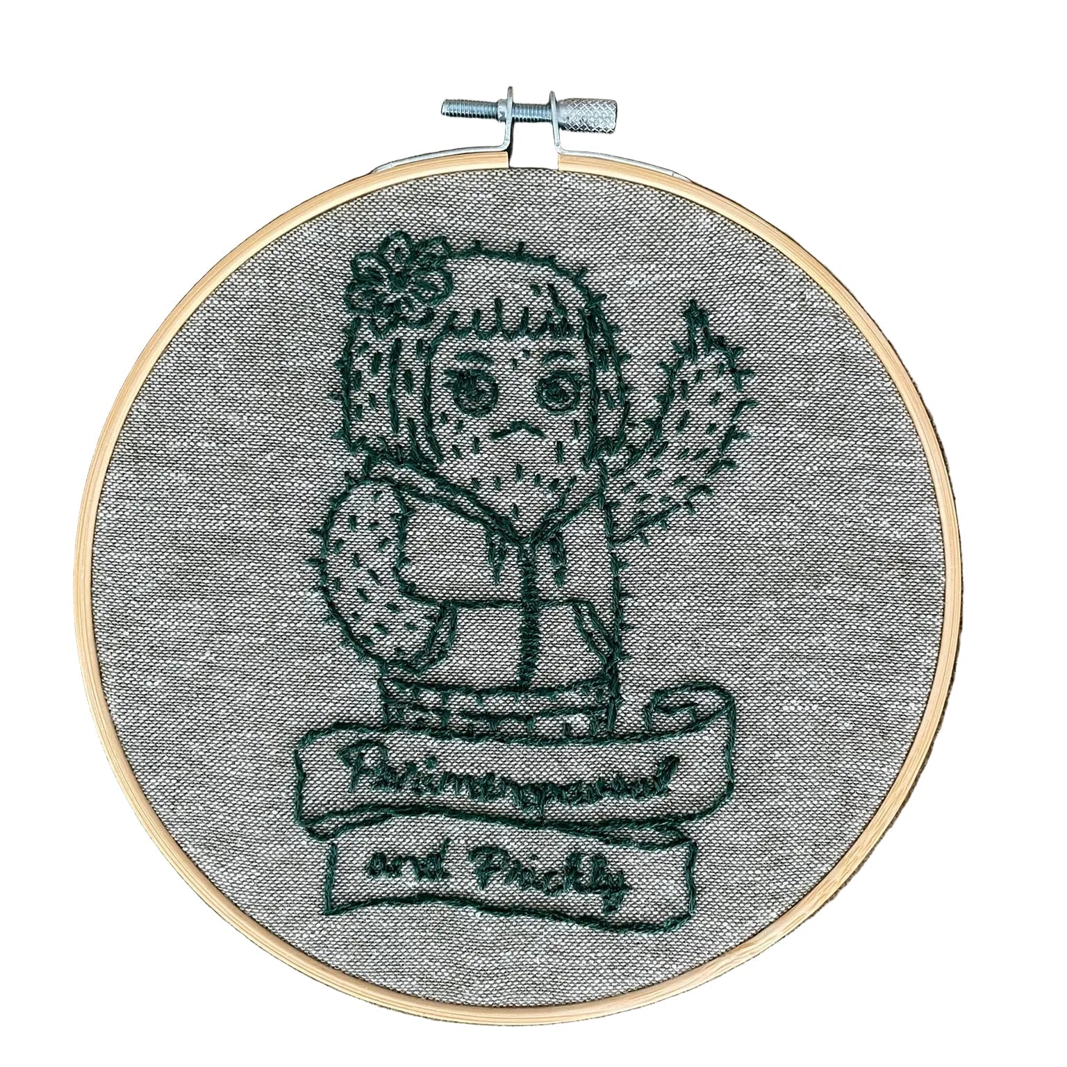 Embroidery hoop with a embroidered design grumpy cactus and text that says perimenopausal and prickly