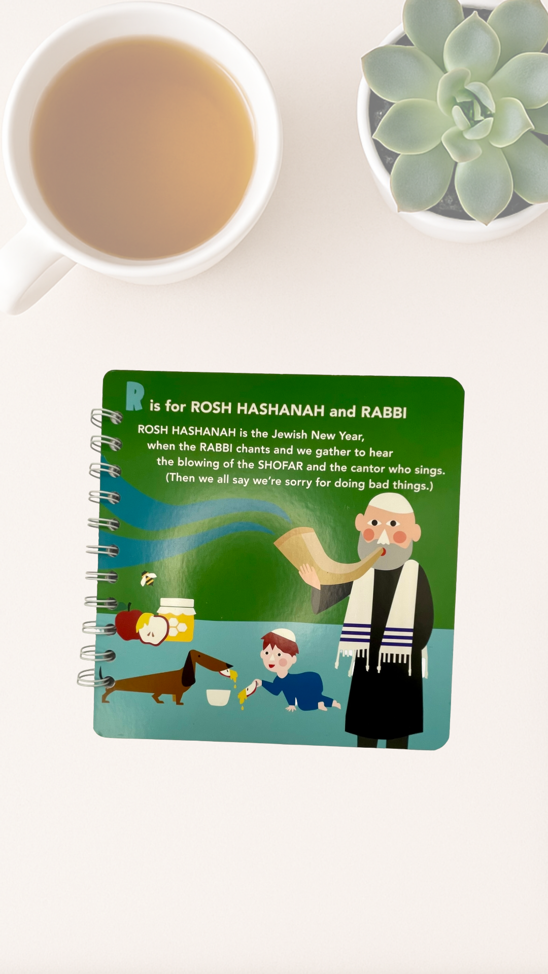 Notebook with a cover of colorful illustration of a Rabbi and child that says R is for Rosh Hashanah and Rabbi