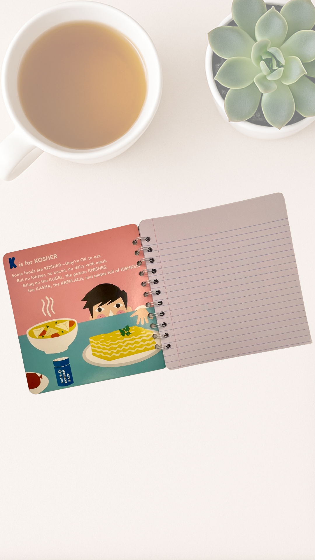 Notebook with a colorful inside cover featuring a child and food that says K is for Kosher