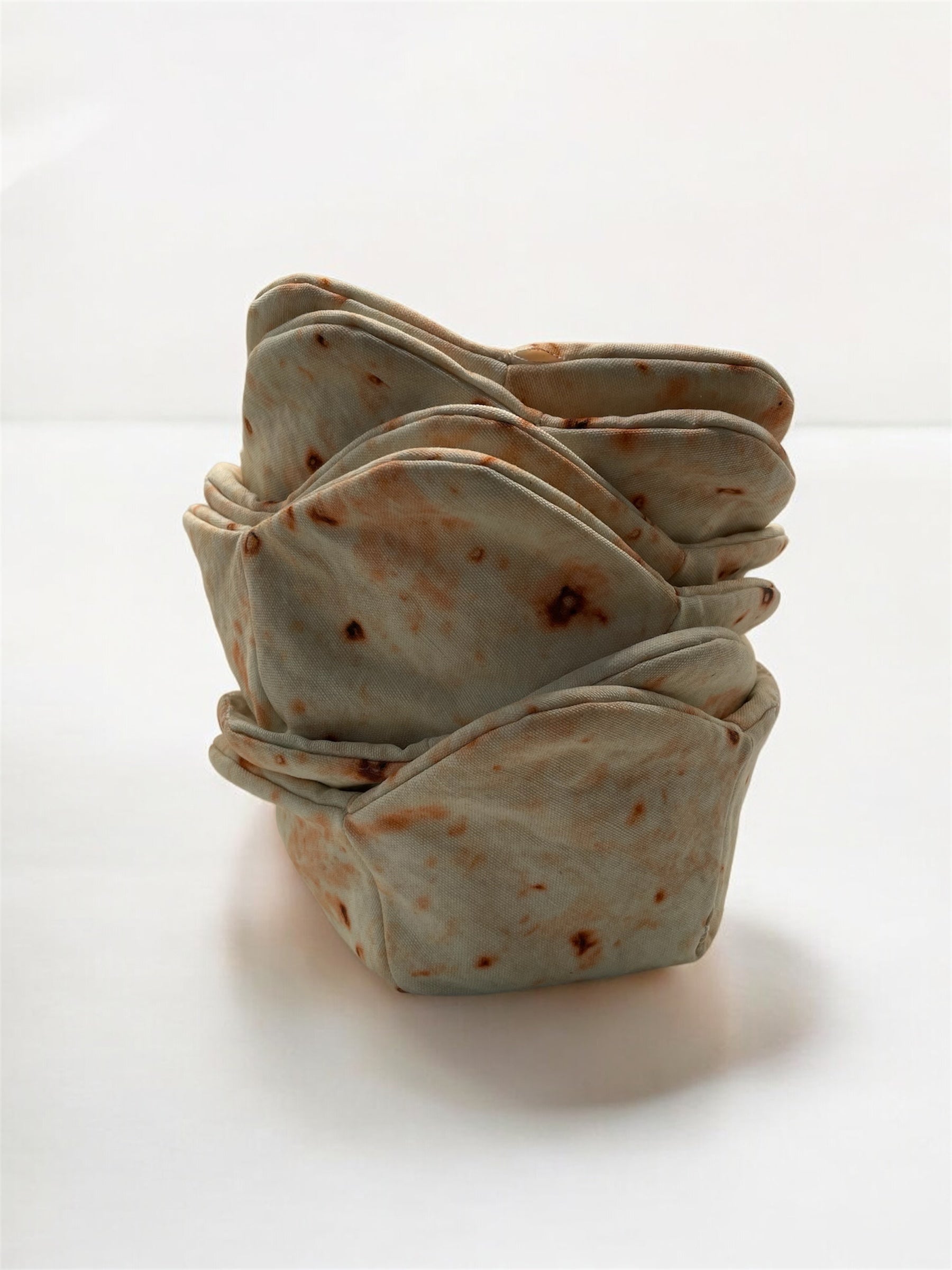 Stack of tortilla-fabric cozies on a white background